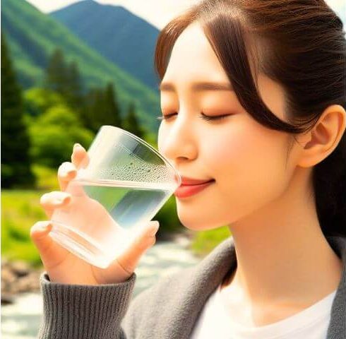 コップで水を飲む女性